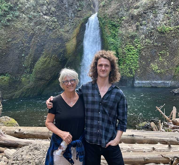 A man and woman posing for a photo near a waterfall